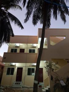 根尼亚古马里Raghavi Tourist Home的前面有棕榈树的建筑