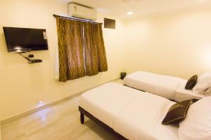 钦奈九霄云外服务式公寓式酒店的客房设有两张床和一台平面电视。