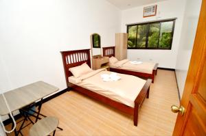 邦劳Tatay Seseng's Apartment的一间卧室设有两张床、一张桌子和一个窗口