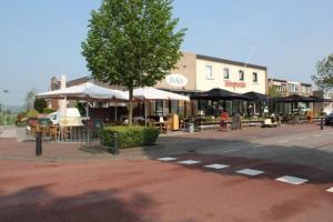 GronsveldB&B - Eetcafe - Riekelt的城市街道上带桌子和遮阳伞的建筑