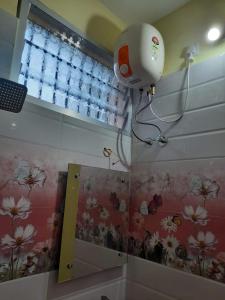 根尼亚古马里Raghavi Tourist Home的浴室墙上的相机,带花卉