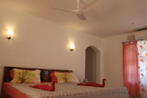 瓦尔卡拉Magnolia Guesthouse Varkala的卧室配有两张红色动物枕头