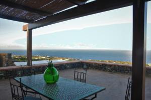 潘泰莱里亚Horizon Pantelleria的绿花瓶坐在阳台上的桌子上