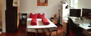 普拉特恩托米斯住宿加早餐酒店的一间卧室配有一张带红色枕头的床和一张书桌