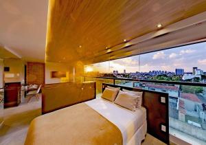 纳塔尔Reserva Madero Loft Natal Hotel的一间卧室设有一张床和一个大窗户