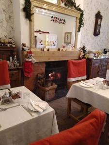 勒兰蒂德威尔斯Llanwrtyd Hall B&B Angelis Holistic Retreat的一间带壁炉的用餐室,拥有圣诞装饰
