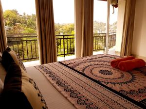 康提Jaye's Homestay的一间卧室设有一张床,享有阳台的景色