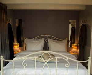NumansdorpBed & Breakfast De Schuur Inn的卧室配有带两盏灯的白色床