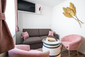约伊斯Winzerhof Lentsch的客厅配有沙发和粉红色椅子