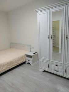 敖德萨1-к кв ж/м Радужный的一间卧室配有一张床、梳妆台和镜子