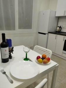 敖德萨1-к кв ж/м Радужный的一张桌子,上面放着一碗水果和一瓶葡萄酒