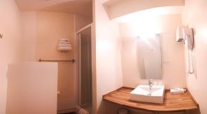 勒波诺Hotel Alicia Auray Le Bono的一间带水槽和镜子的浴室