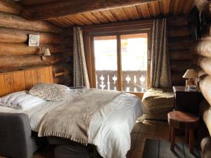 莱德萨阿尔卑斯Chalet Le Ranch的小木屋内一间卧室,配有一张床
