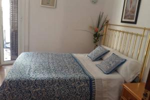 巴塞罗那Chopin Magic Fountain的一间卧室配有一张带两个蓝色枕头的床