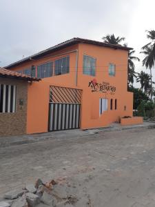 圣阿马鲁Pousada Beira Rio的一座橙色的建筑,旁边标有标志