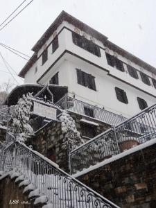 马克里尼撒Charis Guesthouse的一座在台阶上积雪的建筑