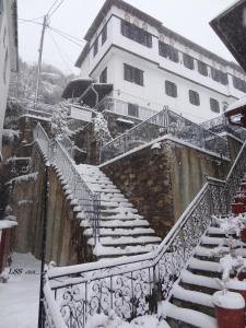 马克里尼撒Charis Guesthouse的大楼前的雪覆盖楼梯