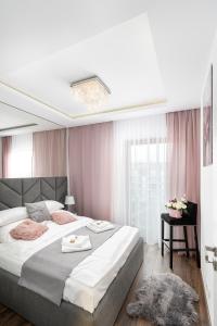 克拉科夫Crystal Luxury Apartments Rakowicka 20H的一间卧室配有一张带粉红色窗帘的大床
