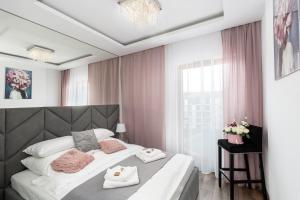 克拉科夫Crystal Luxury Apartments Rakowicka 20H的一间卧室配有一张带粉红色窗帘的大床