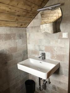 索内纳尔佩·纳斯费尔德Stubihuettn的浴室设有白色水槽和木制天花板