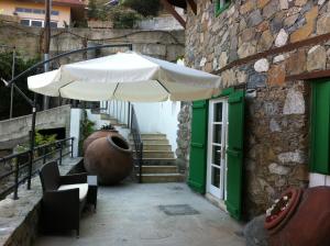 卡洛帕尼亚伊奥蒂斯埃琳娜乡村民宿的坐在大楼旁边的白色遮阳伞