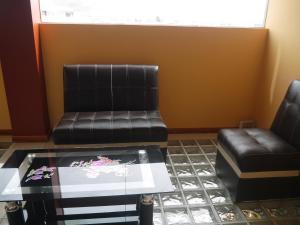 胡利亚卡Hotel Suite Juliaca的等候室配有两把椅子和一张茶几