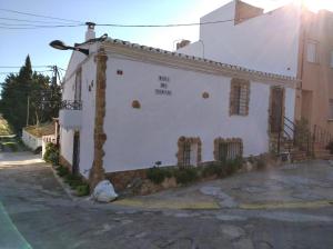 卡马尔莱斯Casa Rural COMPLEX MASIA DEL TREMENDO y Agroturismo的白色的建筑,旁边标有标志
