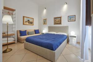 佛罗伦萨Florence&Us Santa Croce的一间卧室配有蓝色的床和沙发