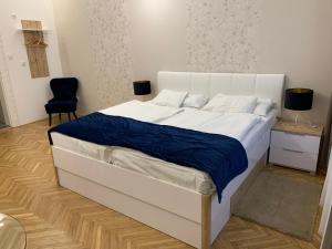 米什科尔茨W19 Apartments的一间卧室配有一张白色的床和蓝色的毯子