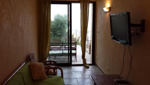 卢米奥卡斯特里亚别墅的一间带电视和滑动玻璃门的客厅
