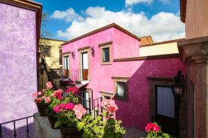 圣米格尔-德阿连德El mesón del Quijote的前面有鲜花的粉红色建筑