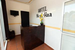 伊萨马尔Nicol-Haa的墙上有酒店小都市标志的房间