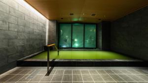 福冈Hotel Vista Fukuoka Nakasu-Kawabata的一间设有绿色地板和窗户的客房