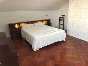 马亚达洪达Alojamiento MARTEL的卧室配有白色的床,铺有木地板