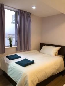 香港New hoover hostel的一间卧室配有一张床,上面有两条毛巾