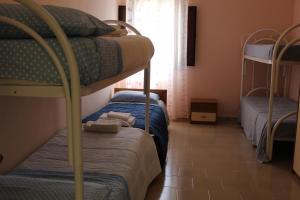 加利波利Agriturismo Tenuta La Siesta的客房设有两张双层床和一扇窗户。
