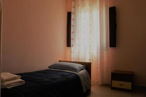 加利波利Agriturismo Tenuta La Siesta的一间带床和窗帘的小卧室