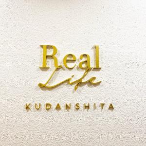 东京Real Life Kudanshita的墙上的金牌上写着真正的“屈服”