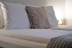 克拉科夫Krak Apartments的一张带白色床单和枕头的床