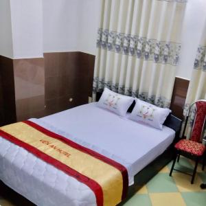 芹苴Kiến An Hotel Cần Thơ的一间卧室配有一张床和两把椅子