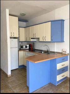 拉斯内格拉斯Acogedor apartamento junto al mar的厨房配有蓝白色橱柜和水槽