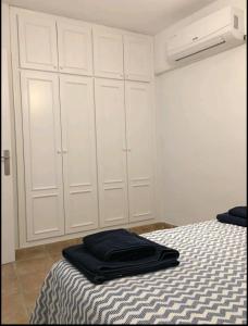 拉斯内格拉斯Acogedor apartamento junto al mar的一间卧室配有床和白色橱柜