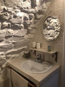 艾日维勒贝日里酒店的一间带水槽和石墙的浴室