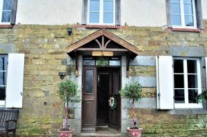 PercyLa Maison du Chene的砖砌建筑,设有木门和窗户
