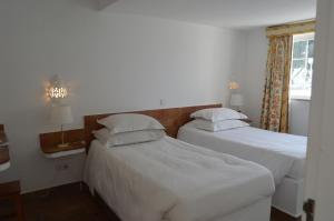 蒙蒂戈杜瓦斯科达伽马酒店的配有2张床的带白色床单和枕头的客房