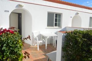 蒙蒂戈杜瓦斯科达伽马酒店的白色的房子,设有配有白色桌子和椅子的庭院