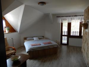 摩拉瓦新村Penzion Bolero的卧室配有床、桌子和窗户。