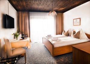 沃尔特湖畔韦尔登尼夫住宿加早餐旅馆的一间卧室配有一张床、一张桌子和一把椅子