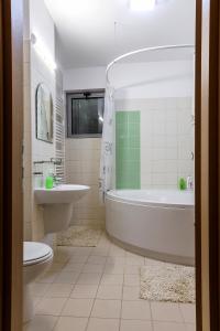 奥林普IRIS LUXURY的带浴缸、卫生间和盥洗盆的浴室