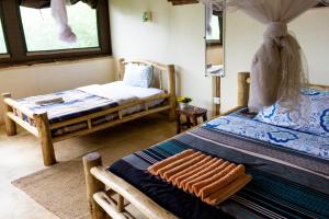 RubuguliKarungi Camp的一间卧室配有两张床和镜子